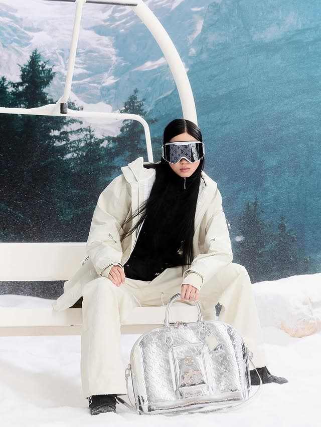 Mac's post from the Louis Vuitton Ski collection: a cream ski jacket and goggles, with the silver Monogram Mirror Alma on a chairlift seat